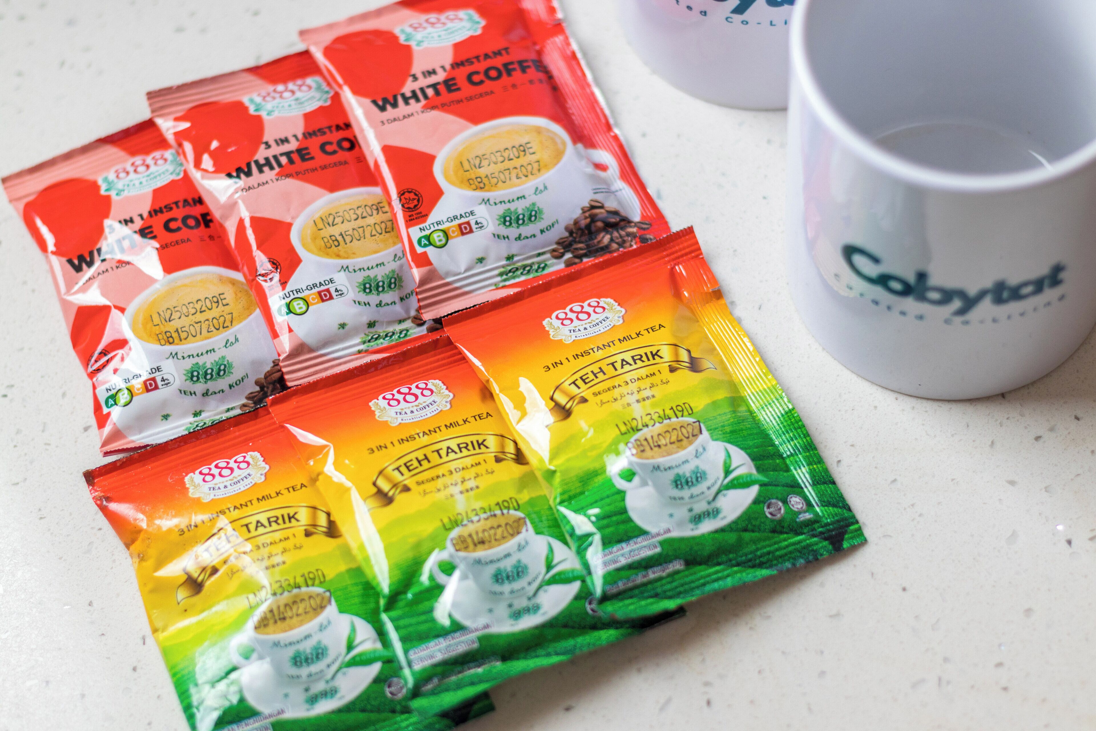 Instant coffee and tea packets on a countertop.