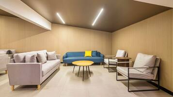 A modern living room with a sofa, armchairs, a coffee table, and a small side table.