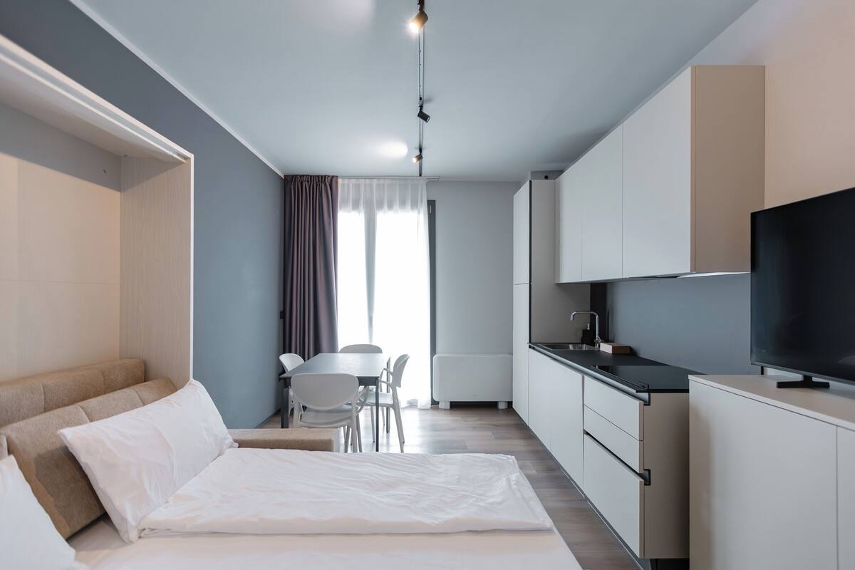 Une chambre d’hôtel moderne équipée d’un lit, d’une table à manger et d’un coin cuisine.