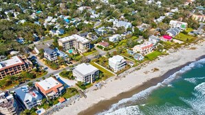 An aerial view of a coastal residential area with houses, a beach, and ocean waves. - 1035 Beachview Dr in Saint Simons Island, GA (Saint Simons Island)