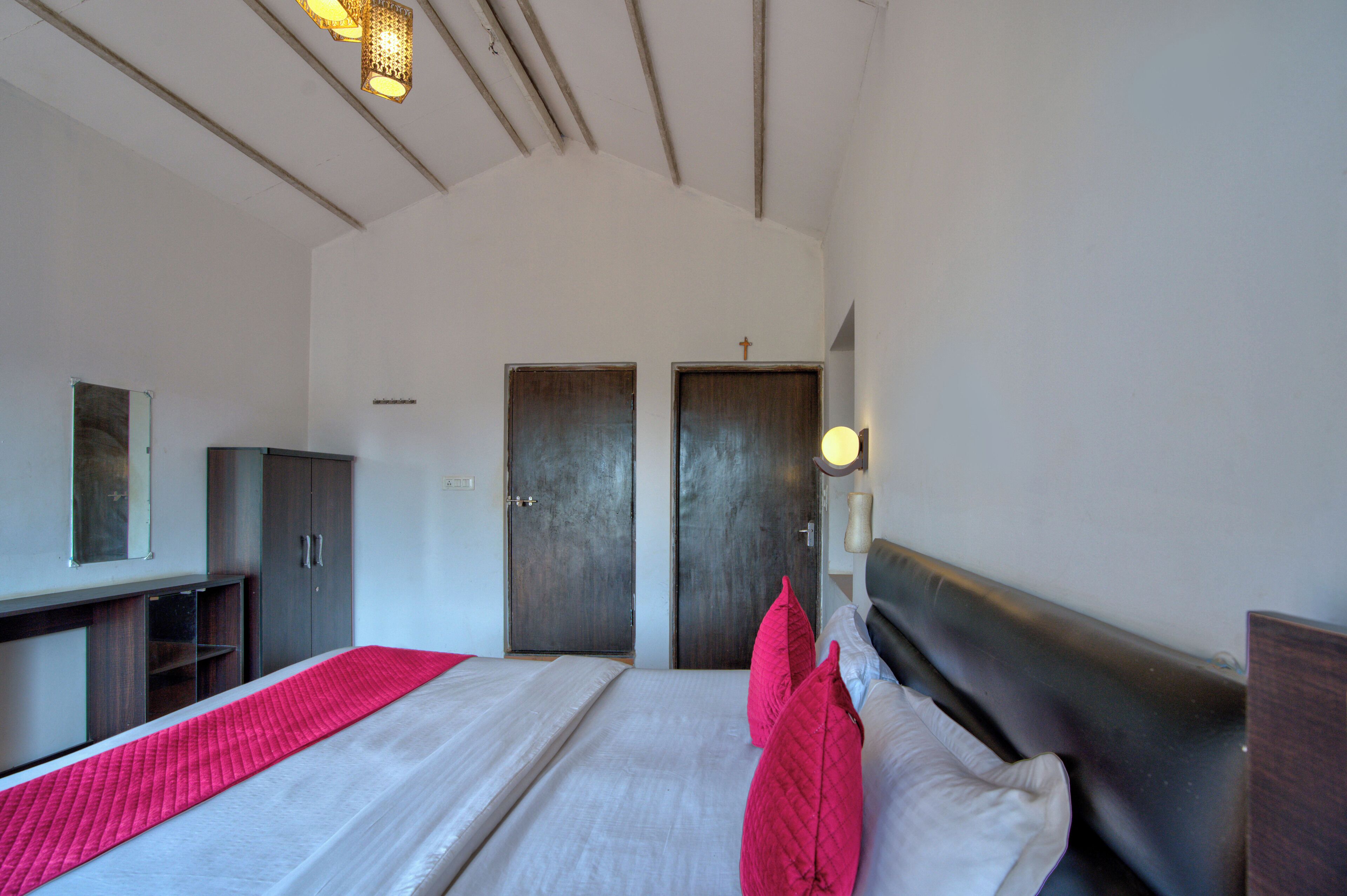 Una camera da letto con un letto grande, due porte, un armadio e una scrivania.