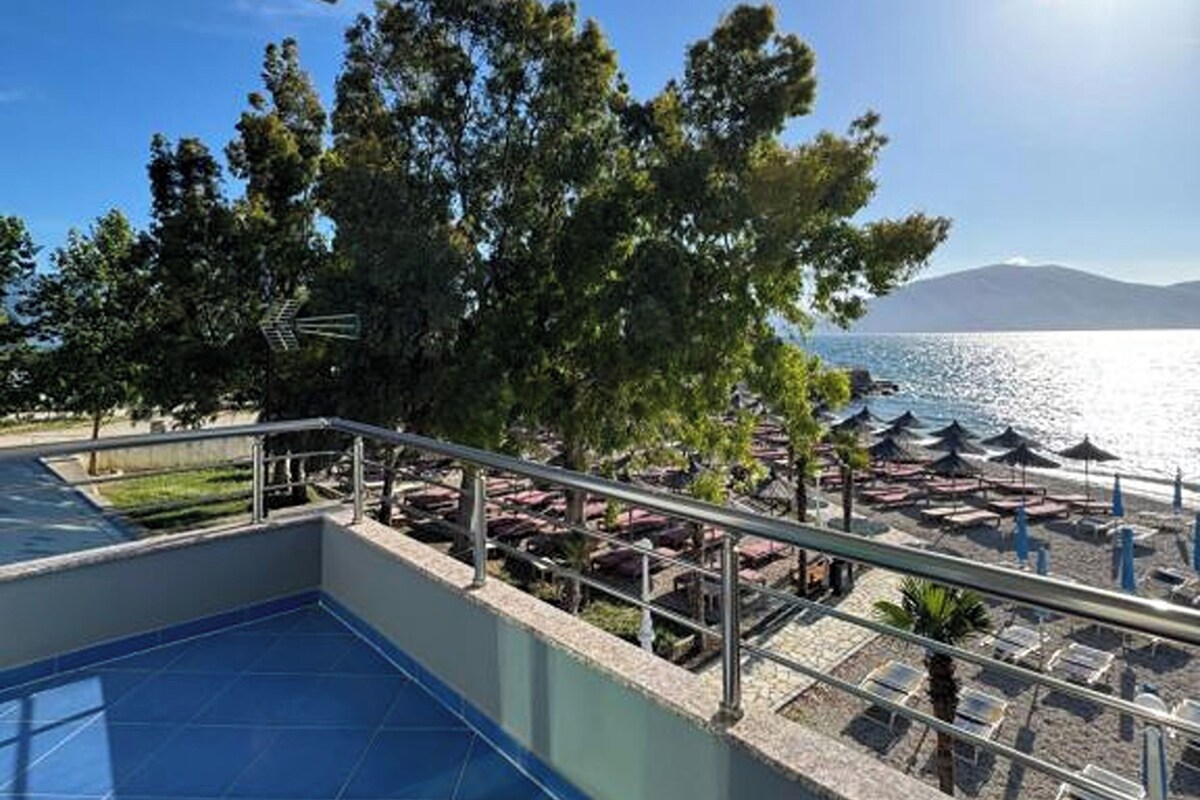 A pool area with a view of the sea and mountains.