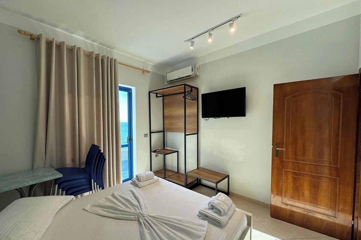 Une chambre d’hôtel équipée d’un lit, d’un bureau, d’une chaise, d’une télévision et d’une armoire.