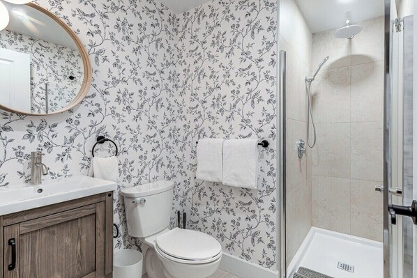 A bathroom with a toilet, sink, and shower. - Beautiful Vieux Quebec 2 Bed Apt (Québec)