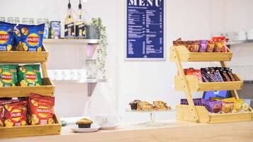 A snack display with various packaged snacks and a menu board in the background.