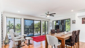 A spacious dining area with a large table, multiple chairs, and a ceiling fan. - Your Ultimate Beachside Escape in the Heart of Casuarina! (Casuarina)