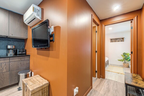 A compact kitchen with a built-in oven, a coffee maker, and a small refrigerator. - Quebec City 2 Bedroom Treasure (Québec)