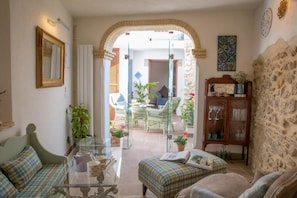 A cozy living room with a sofa, a glass coffee table, and a dining area with a table and chairs.
