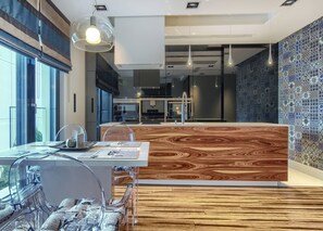 Una cocina moderna con una isla de madera, ventanas amplias y vistas a la ciudad.