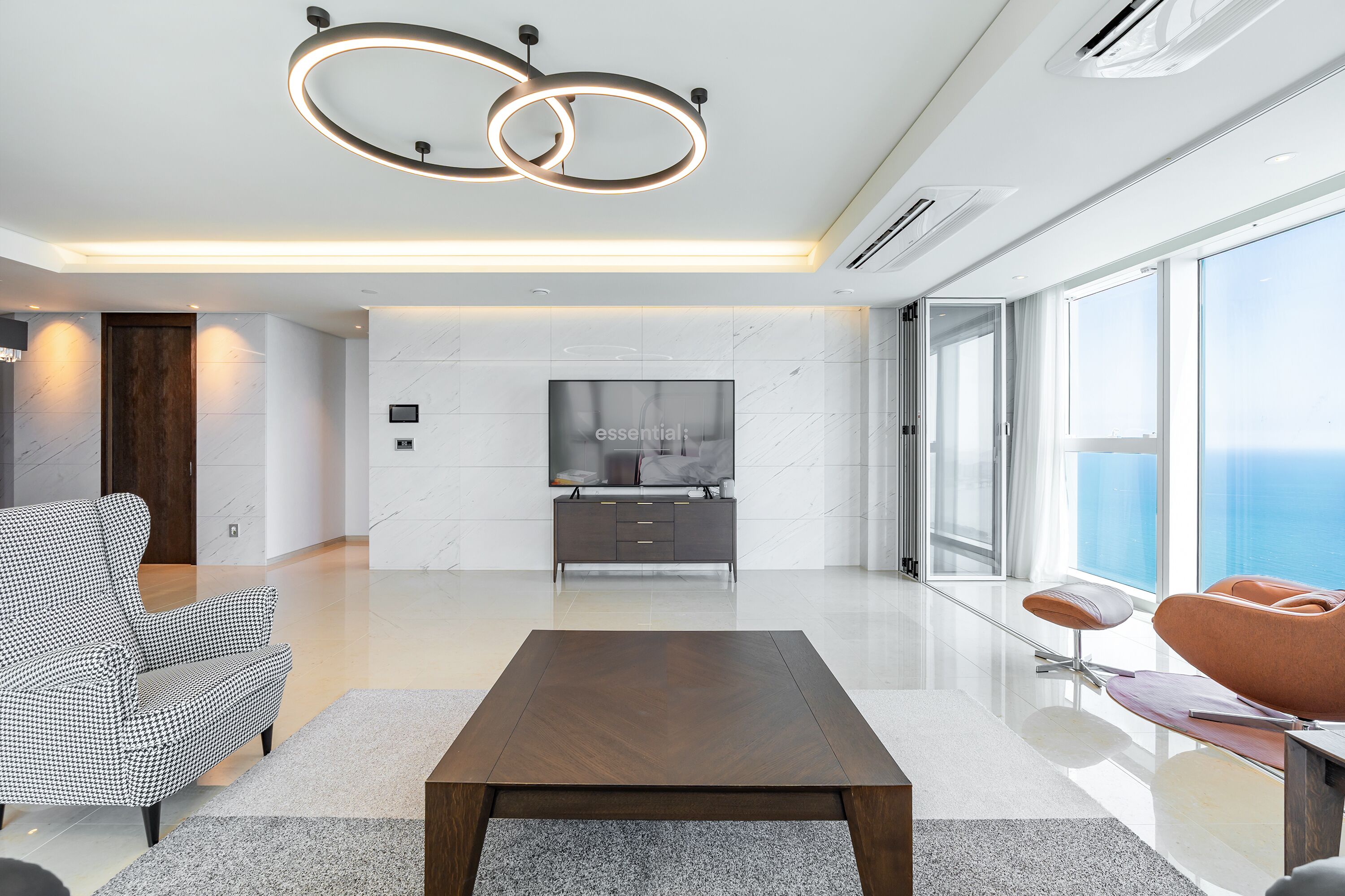A modern living room with a flat-screen TV, a wooden coffee table, and a sofa.