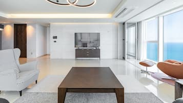 A modern living room with a flat-screen TV, a wooden coffee table, and a sofa.
