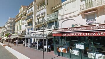 A street view with a restaurant named 'RESTAURANT CHEZ AS' and a shop with a sign 'LE LENDEZ-VOUS'.