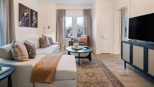 Un salon moderne avec un canapé, une table basse et un téléviseur.