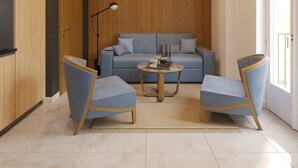 A modern living room with a sofa, two armchairs, a coffee table, and a floor lamp.