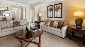 A living room with two sofas, a coffee table, a lamp, and framed artwork on the wall. - Coastal Comfort & Elegance: Oceanfront 2BR Escape (North Myrtle Beach)