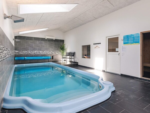 Une piscine équipée d’un vestiaire, d’un espace détente et d’une porte avec une pancarte.