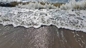 Een strand met golven die op het strand breken.