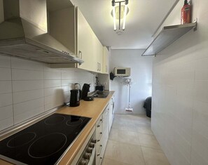 A compact kitchen with a stove, sink, and a microwave. - Bright & Modern Apartment - ER1512LT (Torre-Pacheco)