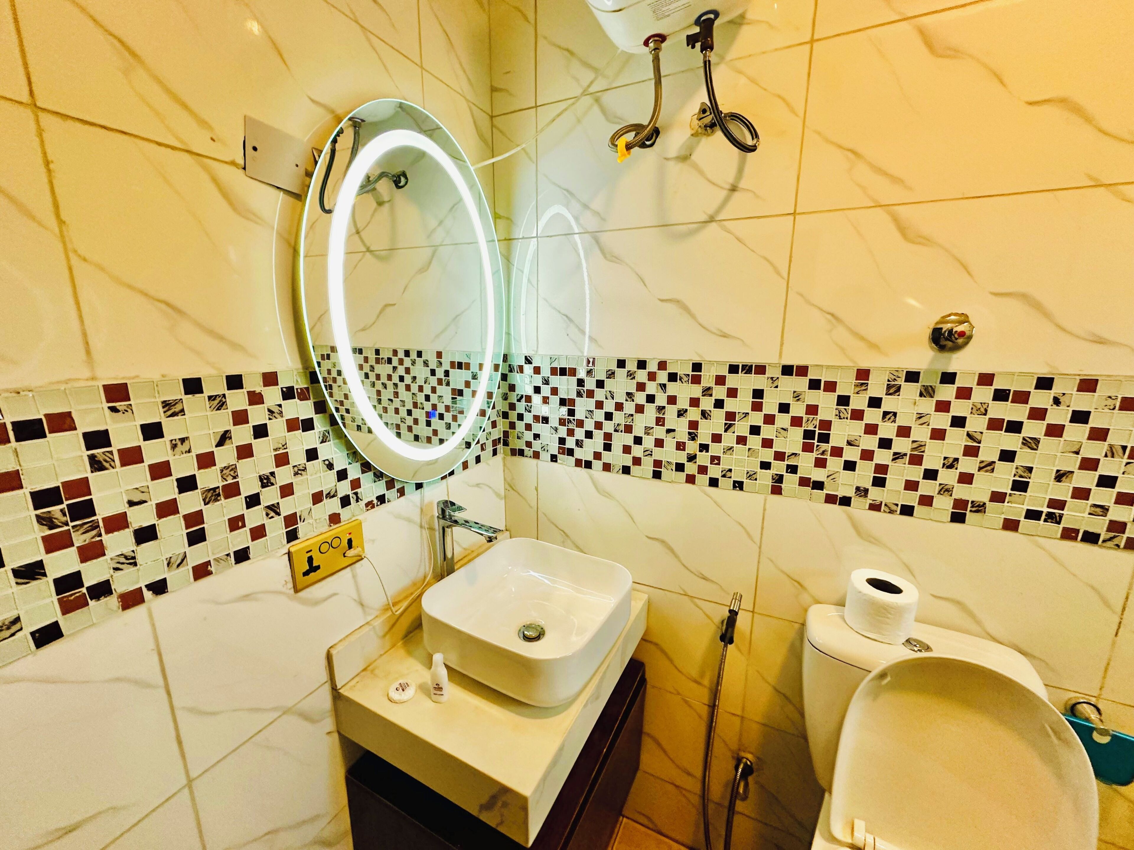 A bathroom with a sink, mirror, and toilet.