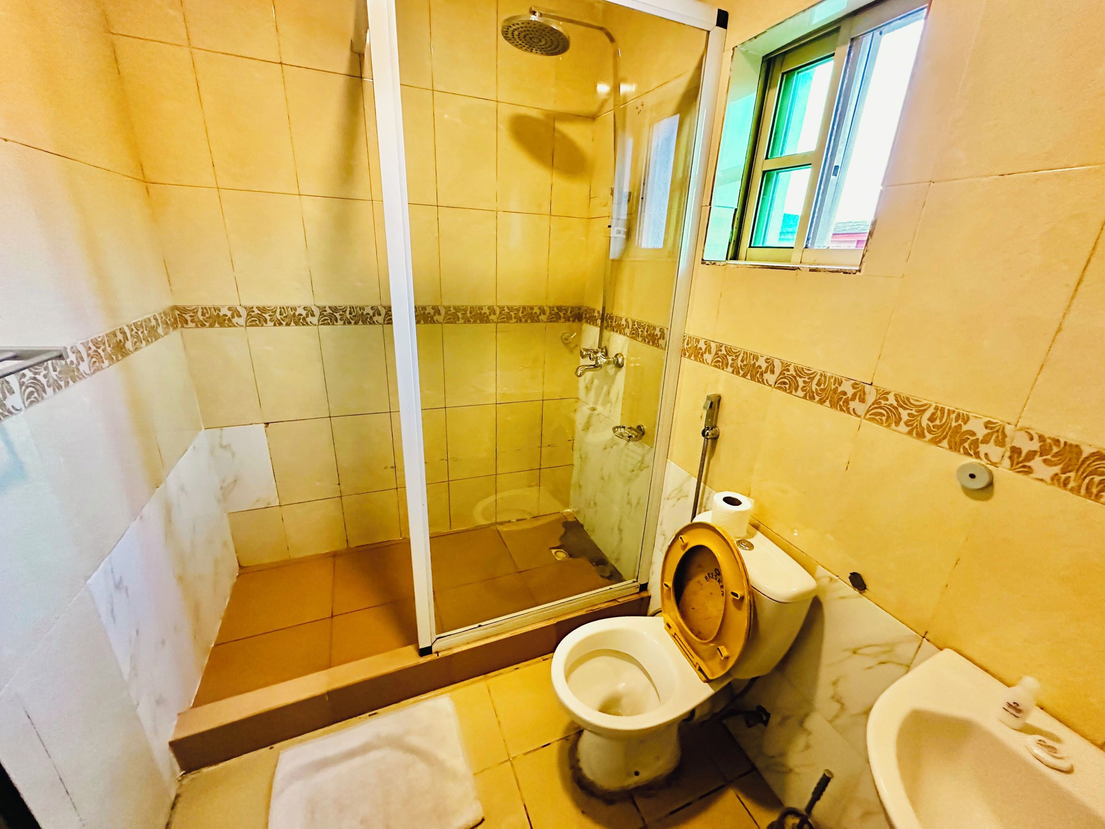 A bathroom with a shower, toilet, and bidet.