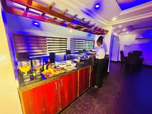 Un buffet proposant une variété de plats et une personne qui sert les clients.