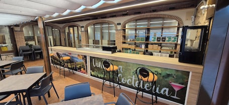 A restaurant interior with a counter, bar stools, and a mural with the word 'Vina'.