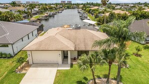 A residential area with a river, houses, and a boat dock. - What a View -Gulf Access, Southern Exposure, Pool, Ping-Pong-Waterside Oasis - Roelens (Cape Coral)