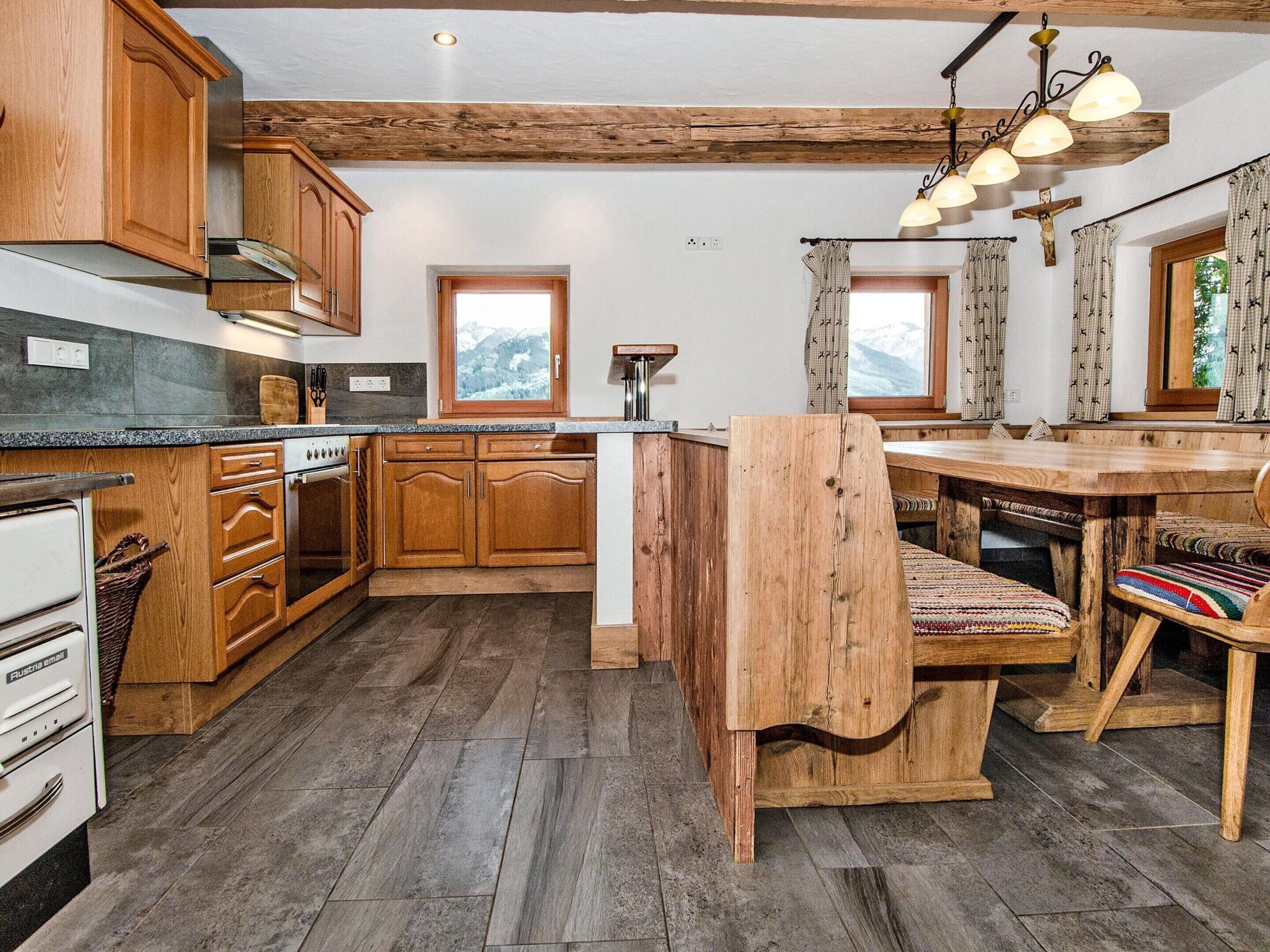 Una cucina rustica con mobili in legno, piano cottura integrato e un'isola grande con una panca.