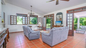 A spacious living room with two grey sofas, a wooden coffee table, and a ceiling fan. - Villa with beautiful pool tropical garden 6 p (Rivière-Salée)