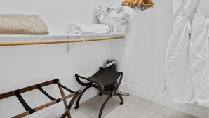 Et moderne, minimalistisk badeværelse med køjeseng, en sort stol og et håndklædetørrestativ.