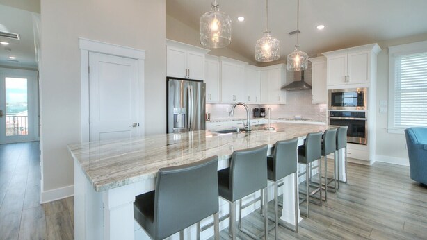 A modern kitchen with a large island, stainless steel appliances, and pendant lighting. - Bob's Legacy: Spacious 5BR, 5BA oceanview home in Oak Island, sleeps 17. (Oak Island)