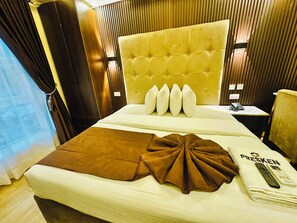 Une chambre d’hôtel avec un grand lit, une table de chevet avec un téléphone et une fenêtre avec des rideaux.