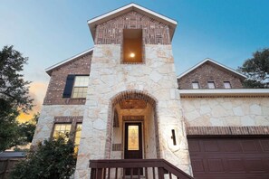 A two-story house with a stone facade, a central archway entrance, and a garage. - Arcade, Billiards with a non heated Pool Two master suites (San Antonio)