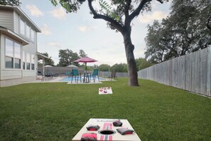 A backyard with a pool, a covered patio, and a wooden fence. - Arcade, Billiards with a non heated Pool Two master suites (San Antonio)