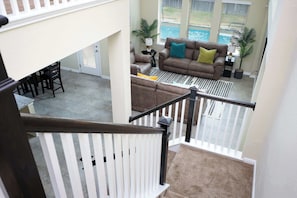 A spacious living area with a brown leather sofa, a white railing, and a view of a pool. - Arcade, Billiards with a non heated Pool Two master suites (San Antonio)