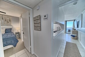Habitación de hotel con cama, mesita de noche, reloj en la pared y una frase motivacional.