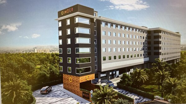 A modern hotel building with a prominent 'GINGER' sign, multiple floors, and a parking area with cars. - Ginger Goa Candolim (Candolim)