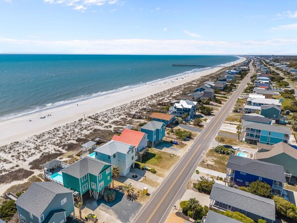 A coastal residential area with houses, a beach, and a pier. - Oceanfront Pool, Private Steps to Beach, New Pool! (Oak Island)