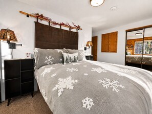 A bedroom with a bed, bedside tables, a mirror, and a window. - Birdhouse in Moonridge - Close to Slopes, Fireplace, Barbecue (Big Bear City)
