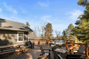 A wooden deck with outdoor seating, a hot tub, and a picnic table. - Lucky Paws - Great Location, Hot Tub, Deck, Barbecue (Big Bear City)