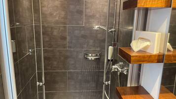 Appartement | Badkamer | Een douche, een haardroger, handdoeken, zeep