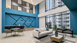 A modern living area with a blue accent wall, a sofa, a coffee table, and a dining set. - w Majestic 1BR w Stunning Balcony View (Panama City)