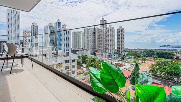 A balcony with a city view, including high-rise buildings and a body of water. - w Majestic 1BR w Stunning Balcony View (Panama City)