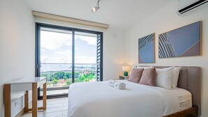 A modern hotel room with a large bed, a desk, and a view of the outdoors. - w Majestic 1BR w Stunning Balcony View (Panama City)