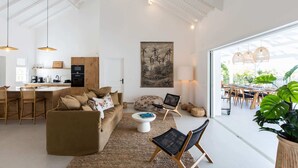 Un salón amplio con techo alto, una zona de comedor con luz natural y una cocina equipada con electrodomésticos modernos.