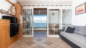 Departamento familiar, 2 habitaciones, vista al mar, junto a la playa | Área de sala de estar | Televisión de pantalla plana