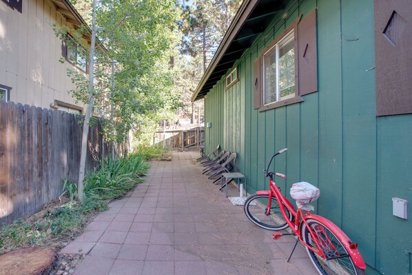 A narrow pathway leading to a building with a green exterior and a red bicycle parked outside. - Walk to Ski Shuttle: Tahoe Cabin w/ Grill! (South Lake Tahoe)