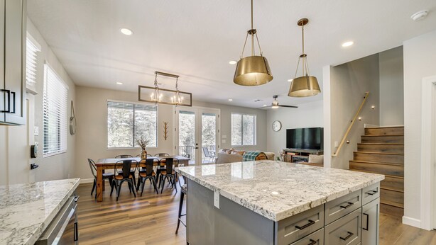 A spacious kitchen with a large island, wooden flooring, and pendant lighting. - Games & Outdoor Seating: Cabin in Scenic Payson! (Payson)