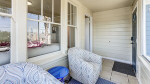 A covered porch with two patterned chairs, a small blue table, and a door with a window. - Oakland Apartment: 8 Mi to Dtwn! (Oakland)
