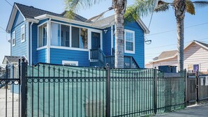 A two-story house with a blue exterior, a front porch, and a green metal fence. - Oakland Apartment: 8 Mi to Dtwn! (Oakland)
